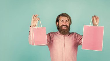 Alışveriş merkezinde alışveriş. Neşeli vahşi hippi hediyeleri. Kağıt alışveriş torbası. Partide doğum günü sürprizi. Paketli adam. Tatil için hazırlanın. En iyi satış teklifi. Mutlu sakallı adam hediye paketiyle