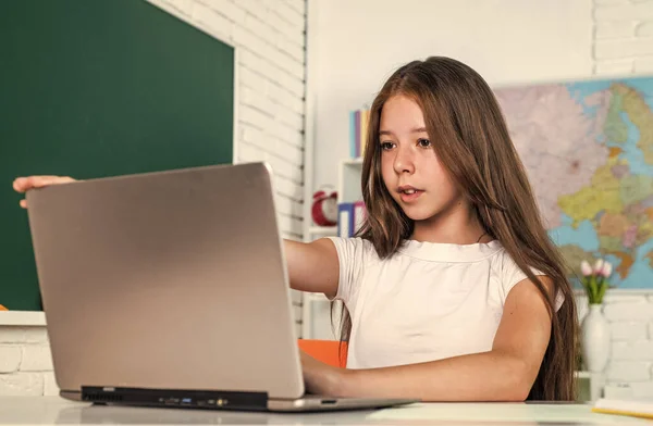 Glada liten flicka med dator i skolan lektion, e lärande — Stockfoto
