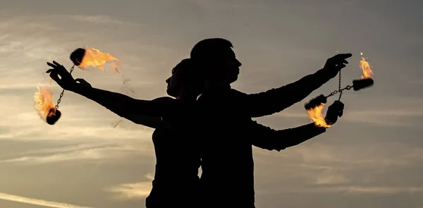 Pareja enamorada realizar fuego poi spinning en la noche sombras en idílico cielo al aire libre, quema —  Fotos de Stock