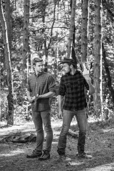 Los guardabosques usan equipo de leñador. Madera con motosierra y hacha. Cosecha leña. senderismo en madera. cuidado del bosque en vacaciones. actividad de verano o primavera. hombre agricultores relajarse en el bosque. vacaciones de verano — Foto de Stock