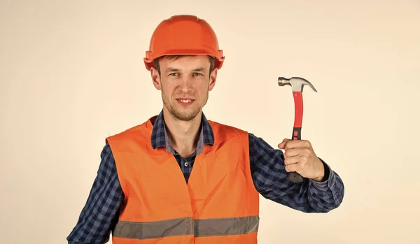 Jonge werknemer is ingenieursassistent. Een reparateur in uniform. Man werkt met hamer. echte bouwvakker in helm. timmerman klaar om te werken. reparatieapparatuur voor bouwgereedschap. Hij houdt van zijn werk. — Stockfoto