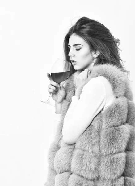 Álcool e tempo frio. A mulher gosta de vinho. Menina moda maquiagem usar casaco de pele segurar copo de vinho. Senhora penteado encaracolado como vinho caro. Conceito de vida de luxo. Razões para beber vinho tinto no inverno — Fotografia de Stock