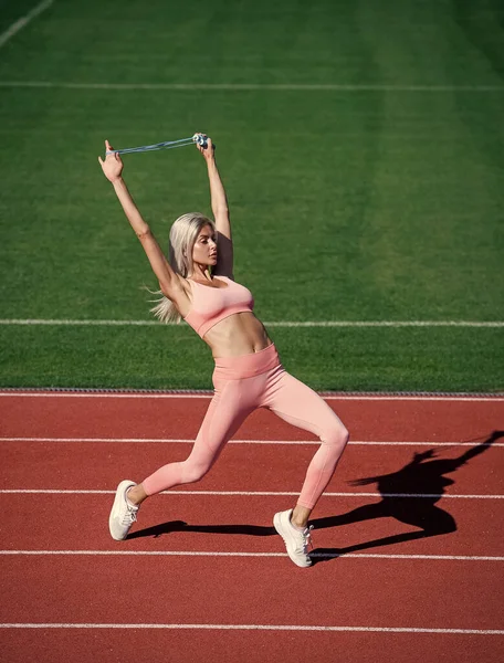 Fitnessz ruhás fitnessz hölgy a stadionban ugrókötéllel sportedzésen, aktivitás — Stock Fotó