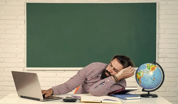 Túlhajszoltam magam a vizsgára készülés közben. főiskolai tanár pihenőórán. Vissza az iskolába. nem formális oktatás. alvó tanár pihenjen az asztalon. brutális szakállas férfi aludni osztályteremben táblával — Stock Fotó