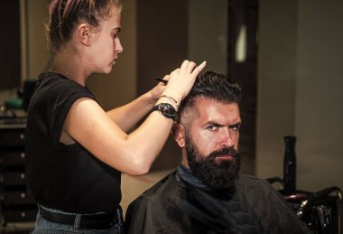 Berber dükkanında yakışıklı bir erkeğin saçını kesen çekici berber, kuaför aletleri.