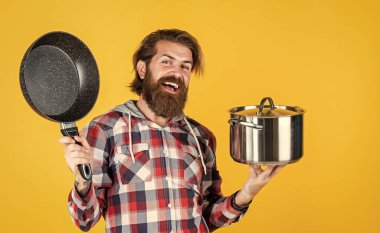 Elinde kızartma tavası olan bir adam... aşçı aşçı bir erkek. Sakallı adam aşçı için hippi gömleği. Mutfak aletleriyle traşsız, vahşi bir adam. Ev eşyaları. Arkadaş canlısı tezgahtar. Yemek partisini getir.