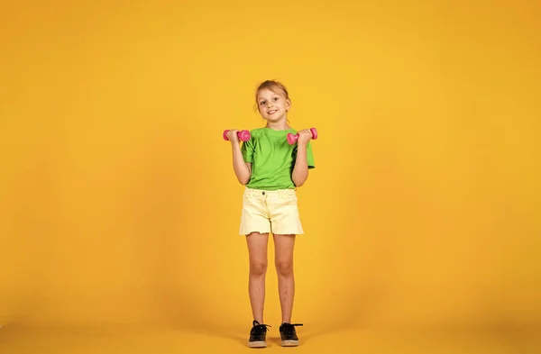 No hay dolor no hay ganancia. estilo de vida saludable. concepto de levantamiento de peso. mancuernas herramientas para la formación. niño sonriente con campanas. felicidad infantil. bastante adolescente en ropa deportiva. moda fitness para niños —  Fotos de Stock