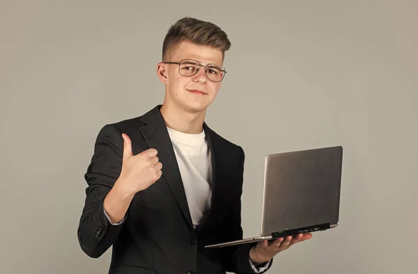 Adolescente chico desgaste formal traje y gafas uso portátil, educación — Foto de Stock