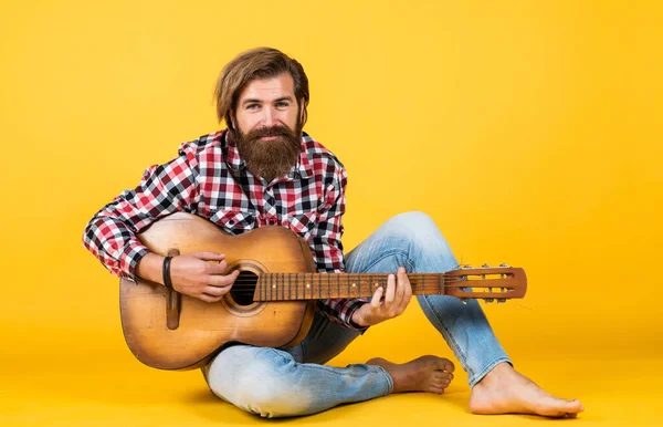 Hipster man playing the acoustic guitar. country music style. man wearing checkered shirt and holding guitar. play string musical instrument. professional caucasian musician. guitarist — Stock Photo, Image