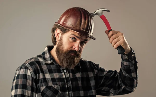 Brutal homem construtor em uniforme e capacete com martelo, reparação — Fotografia de Stock