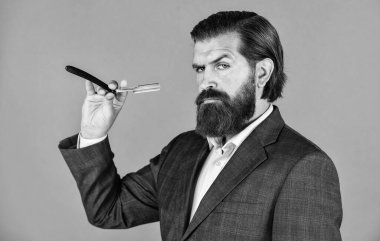 Tıraş olmaya yakın dur. Erkek bakımı. Tıraş bıçağı olan olgun bir iş adamı. Berber dükkanında bıyıklı vahşi hippi. Kuaförde berber. Saç aleti. moda ve güzellik