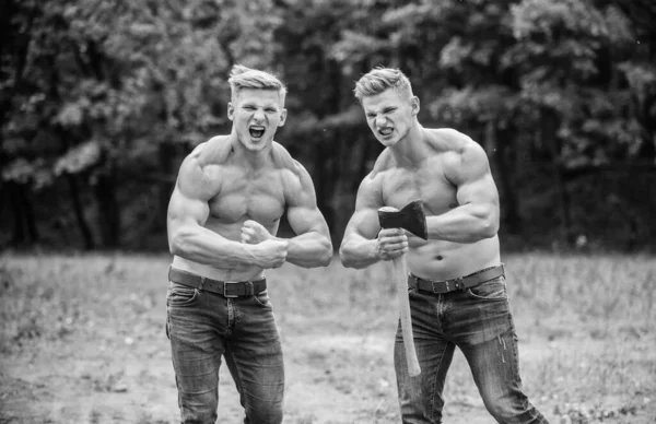 Handsome brothers. Athletic twins use ax. Men with muscular torso. Genetics concept. Brotherhood friendship. Strength and perseverance. Strong men nature background. Group muscular men with axe — Stock Photo, Image
