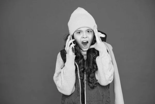 Navidad invierno compras en línea. moda de temporada fría. niño con ropa de abrigo hablar por teléfono. llamar a la familia de vacaciones. Feliz saludo de Navidad. Las felicitaciones de año nuevo. chocado chica adolescente con teléfono inteligente —  Fotos de Stock