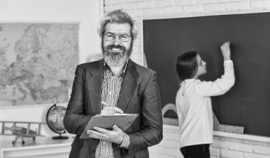 Öğretmen doğru cevabı kontrol ediyor. Tutkuyla öğretiyorum. Öğretim malzemeleri. Kendisi bugün yok. Kara tahtada küçük bir kız. Okula dönelim. Öğrenci ve öğretmen sınıfta. Parça öğrenci süreci