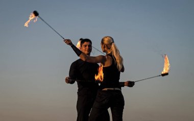 Ritim ve hareketin ahengi. Mavi gökyüzünde poi yapan birkaç dansçı. Ateş dansı. Muhteşem dans koreografisi. Ateşle dans etmek. Sanat gösterisi. Tatil kutlaması