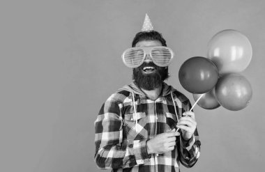Havalı saç stili olan şık sakallı adam kareli gömlek giyer parti balonları, yıldönümü