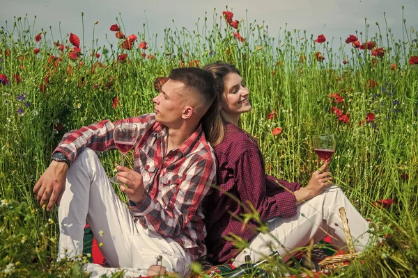Kille och tjej som har romantisk dejt i vallmo blomma fält med gitarr musik och vin, datum — Stockfoto