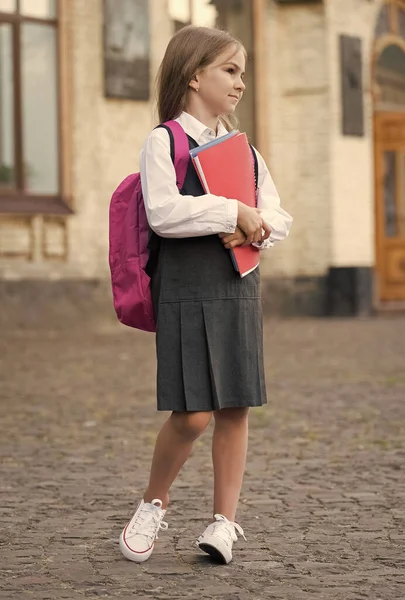 Small kid in formal uniform with back to school look carry bag holding books and supplies, college — Stock Photo, Image