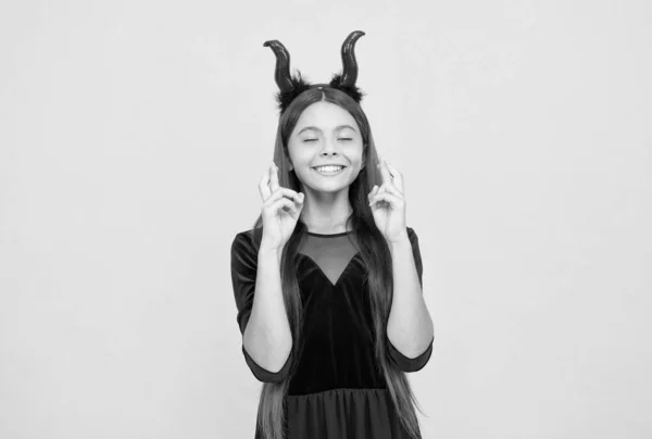 Niño feliz lleva traje de cuernos de diablo en la fiesta de Halloween pidiendo un deseo, sueño de Halloween —  Fotos de Stock