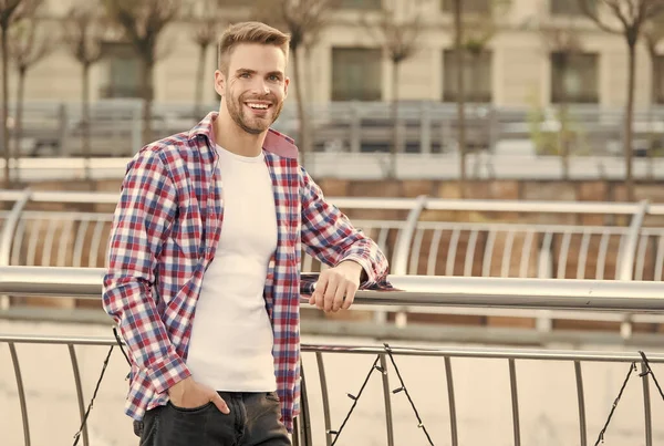 Szczęśliwy uśmiech młody nieogolony mężczyzna z zadbane włosy w kratkę casual koszuli zewnątrz, moda i męski fryzjer — Zdjęcie stockowe