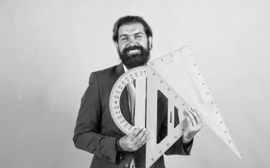 Sakallı ve bıyıklı bir adam üniversitede ya da okulda iş adamı ya da öğretmen gibi görünüyor, matematik.