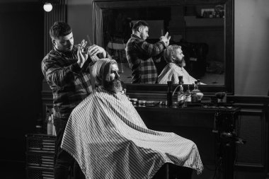 Profesyonel kozmetik. Hippi saç tıraşı oluyor. Sağlıklı saçlar. Sinir bozucu berber kulağına zararlı gelebilir. Bağış ve yardım konsepti. Saçları boyalı adam. Saç kes. Berber berber dükkanı.