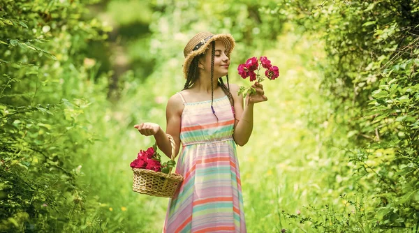 Tolle Pflanzen. Muttertag. glücklicher Frauentag. Porträt eines kleinen Kindes mit Blumen. Liebe und Schönheit. atemberaubende Mädchen mit Strauß Blumen von Rosen. Glückliches Kind mit Strohhut. Frisur der Natur — Stockfoto