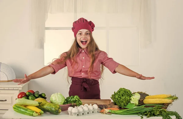Glad liten flicka i kock hatt och förkläde i kök, hälsa — Stockfoto