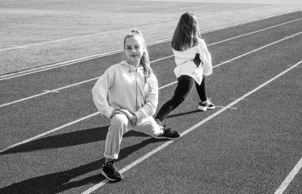 Sağlıklı çocuklar stadyum koşu pistinde spor antrenmanı yapıyor. — Stok fotoğraf