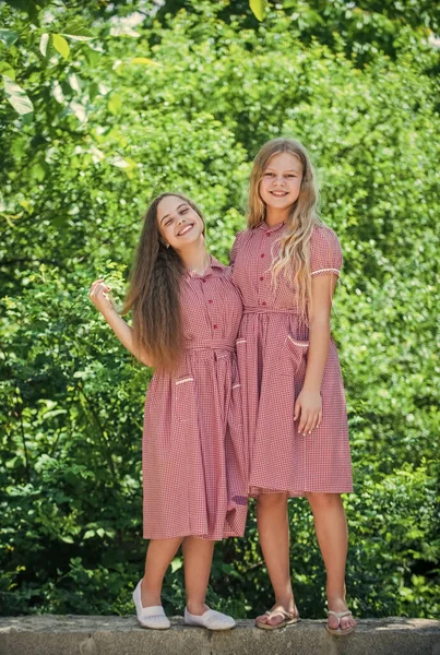 복 고복을 입은 두 소녀 가 바깥에서 자매 행세를 한다 — 스톡 사진