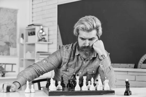 Thinking about next step. Chess is gymnasium of mind. Chess lesson. Strategy concept. School teacher. Board game. Figures on wooden chess board. Smart hipster man playing chess. Intellectual hobby