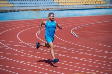 Erkek dayanıklılığı ve dayanıklılığı. Başarılı sporcu bitiriyor. Sporcu ya aerobik ya da anaerobik yükleme yapar. Stadyumda koşmaya başla. Spor salonu açık havada. Kas sporu antrenmanı. spor
