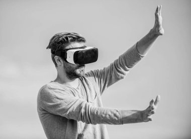 Yeni deneyimlerin tadını çıkarıyorum. Kendi işini kur. Sanal oyun oyna. Seksi adam gökyüzü arkaplan gözlüğü. Dijital dünyadaki erkek gerçekliği. VR kulaklığı kullan. Maço adam kablosuz VR gözlük takıyor..