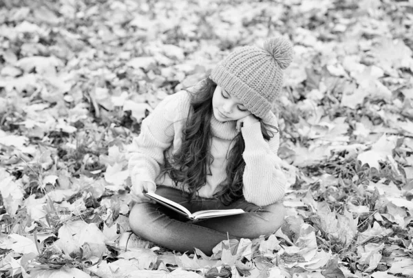 Reading really matters. Little child read book sitting on fall leaves. School library. Knowledge and informaiton. Imagination and fantasy. Literacy education. Reading grows on you — Stock Photo, Image