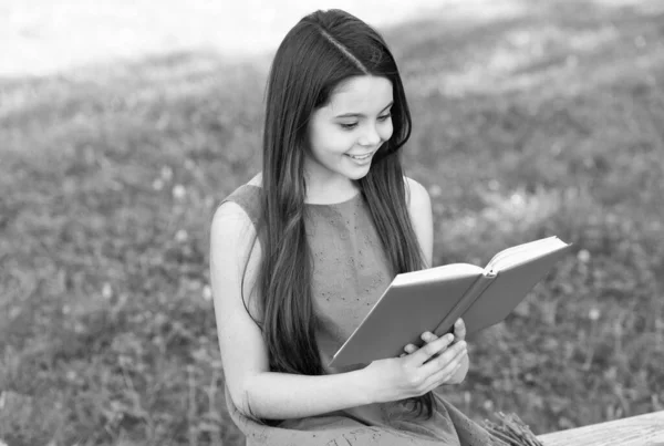 Little happy girl czytanie książki na świeżym powietrzu słoneczny dzień, fajne pojęcie historia — Zdjęcie stockowe