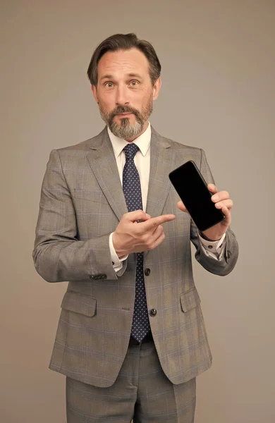 Man επίσημη διευθυντής ρούχα δείχνει την οθόνη του κινητού, την εφαρμογή ενημέρωση έννοια — Φωτογραφία Αρχείου