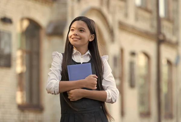 Ett nytt utbildningsperspektiv. Glada barn i uniform hålla bok. Skolbiblioteket. Grundskola. Privat undervisning. Privatlektion. 1 september. Uppstart. Kunskapsdagen. Utbildning för framtiden — Stockfoto