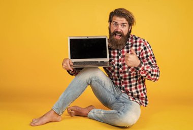 En iyi kalite. Laptop kullanarak. Online öğrenme kavramı. Sosyal mesafe. Defteri olan özenli bir adam. Kareli tişörtlü sakallı adam internette ders dinliyor. webinar ve iş eğitimi