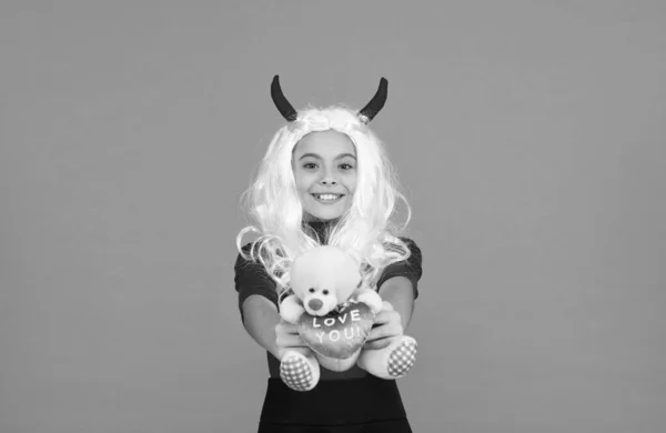 Gift with love. best gifts and presents. trick or treat. celebrate the holidays. happy halloween devil girl. teenage child in imp horns. cheerful kid hold teddy bear toy. shopping in toy shop — Stock Photo, Image