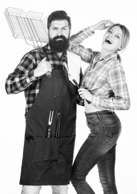 Tam bir barbekü tabağı. Aile barbeküye hazırlanıyor. Sakallı hippi ve kız ızgara çatal bıçaklarını beyaz arka planda tutuyorlar. Piknik ve barbekü. Arka bahçe barbekü partisi. Birlikte yemek pişirmek.