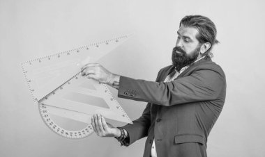 Sınavı geç. Konuyu öğrenmek. Okula dönüyorum. Öğretmenler günün kutlu olsun. Sakallı vahşi adam matematik aletleri kullanıyor. gayri resmi eğitim. Erkek öğrenci ders sırasında sınıfta oturur.