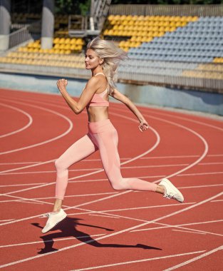 Formda bayan spor ve dayanıklılık yaparken stadyum yarış pistinde koşuyor.