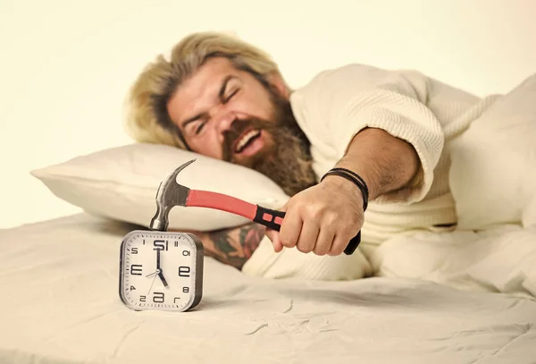 Enerji ve yorgunluk. Yatakta sakallı bir adam çalar saat çalıyor. Zaman yönetimi. Rahatlamaya ihtiyacım var. Sinir bozucu çalar saat. Disiplini boz. Uyanma zamanı. Sabah rutini — Stok fotoğraf