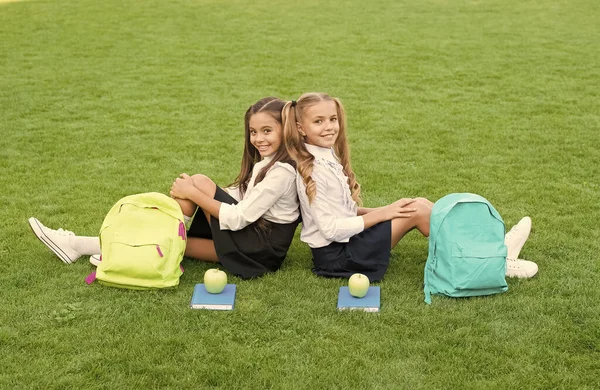 W przyjaźni jest szczęście. Szczęśliwe dzieci cieszą się przyjaźnią. Przyjaciele ze szkoły siedzą na zielonej trawie. Małe dzieci wracają do szkoły. Międzynarodowy dzień przyjaźni. Lojalność i zaufanie to przyjaźń — Zdjęcie stockowe