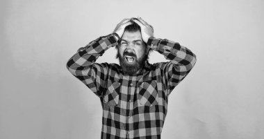 Başım ağrıyor. Modern görünümlü sakallı hippinin başı ağrıyor. Sağlık hizmeti konsepti. Bıyıklı vahşi yakışıklı adam. Mavi arka planda olgun bir berber. Erkeklik ve karizma. Hayır.