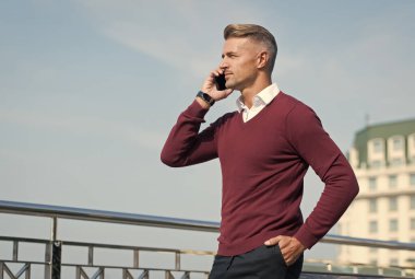 Modern iletişim. İş adamı cep telefonunu tutar. Dışarıda telefonu olan yakışıklı bir adam. Taşınabilir yaşam tarzı. İnternet bağlantısı. Kullanışlı bir uygulama. İş iletişimi. Çevrimiçi iletişim