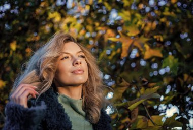 Sonbaharda seksi bir kadın sonbahar ormanında sıcak kıyafetler giyer ya da yapraklarla park eder, sonbahar mevsimi