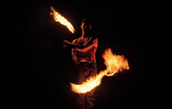 Fakir show. Happy man manipulate with burning poi. Fire fakir perform dangerous tricks.