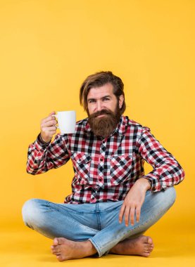 Sarı arka plandaki sakallı adam için sabah kahvesi, ilham ve enerji.