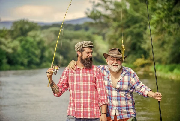 家族の時間だ。活動と趣味。淡水湖の池の川釣り。釣り竿を持つ漁師。髭を生やした男が魚を捕まえる。友人釣りの熟女.夏休みだ。幸せな陽気な人々 — ストック写真